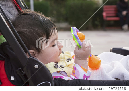Beautiful baby playing with her toys at carriage 39724518