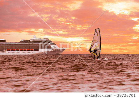 Windsurfer in the sea with a cruise ship Windsurfer in the sea with a cruise ship 39725701
