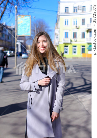 Woman strolling outdoors and wearing grey coat Woman strolling outdoors and wearing grey coat 39728378