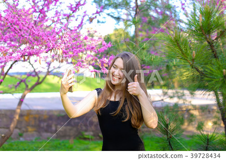 Girl making video call by smartphone in spring 39728434