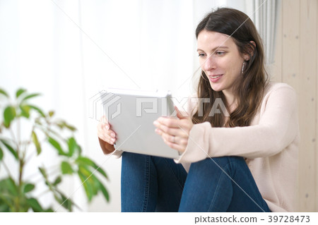 Woman (westerner) who sees tablet PC in room 39728473