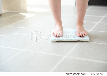 Female feet on weight scale Female feet on weight scale 39728763