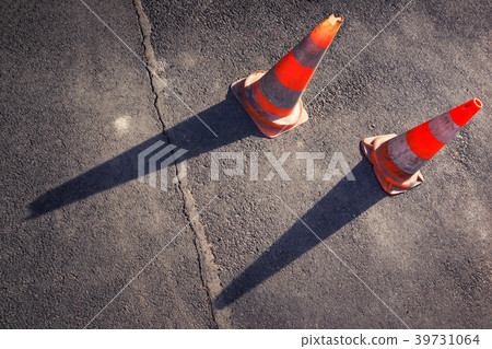 Two orange road cones on the gray asphalt Two orange road cones on the gray asphalt 39731064