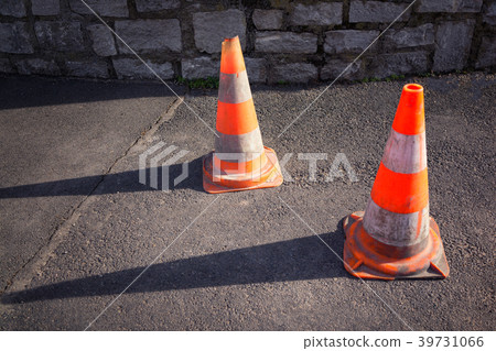 Two orange road cones on the gray asphalt Two orange road cones on the gray asphalt 39731066