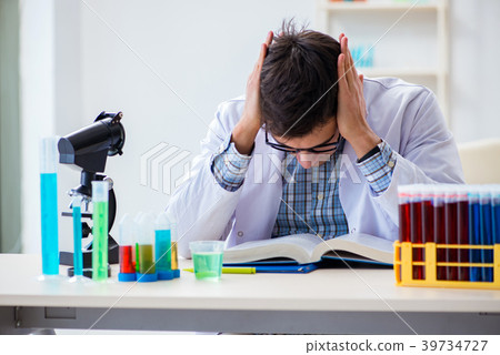Young chemist student working in lab on chemicals 39734727
