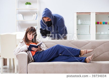 Armed man assaulting young woman at home 39734834