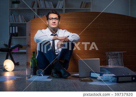 Stressed businessman working overtime in 39737920