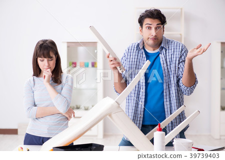 Wife helping husband to repair broken chair at 39739403