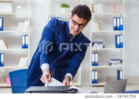 Businessman angry at copying machine jamming Businessman angry at copying machine jamming 39741759