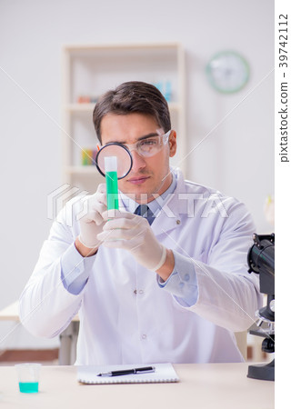 Man student working in chemical lab on experiment Man student working in chemical lab on experiment 39742112