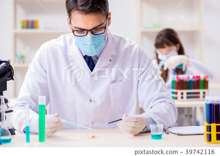 Two chemists working in lab experimenting Two chemists working in lab experimenting 39742116