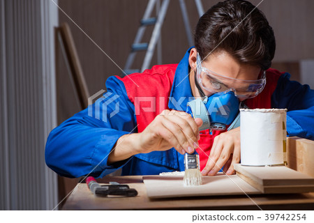 Young man gluing wood pieces together in DIY 39742254