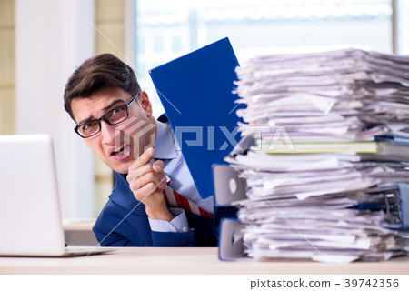 Businessman workaholic struggling with pile of Businessman workaholic struggling with pile of 39742356