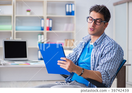 Young designer working on new project and choosing Young designer working on new project and choosing 39742439