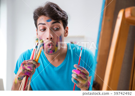 Young funny artist working on new painting in his 39742492