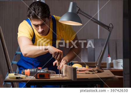 Worker working in repair workshop in woodworking Worker working in repair workshop in woodworking 39742630