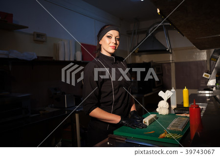 woman Cook prepares sushi on restaurant kitchen woman Cook prepares sushi on restaurant kitchen 39743067