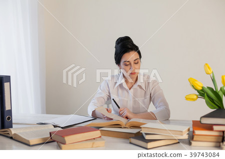 girl reading book at the table in the Office 39743084