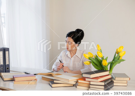 girl reading book at the table in the Office 39743086
