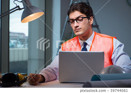 Construction architect working on drawings late at 39744081