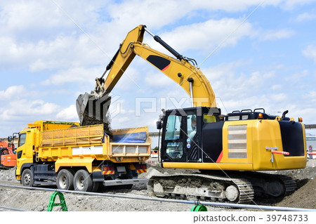 A hydraulic excavator loading surplus soil into a dump 39748733