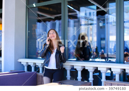 Female person talking by smartphone at street cafe Female person talking by smartphone at street cafe 39749180