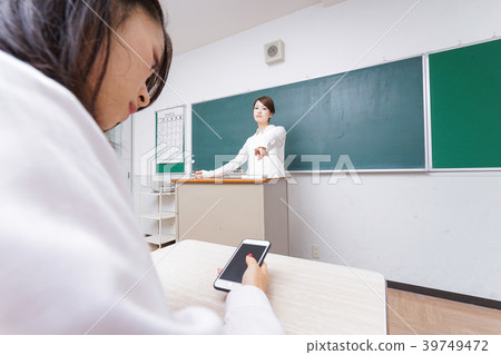 Teacher who is careful with student using smartphone during class Teacher who is careful with student using smartphone during class 39749472