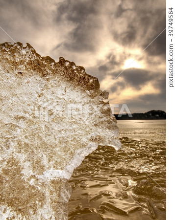 Frozen mud, puddle of water. Brown silver ice 39749564