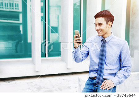 Happy Businessman Smiling while using Smartphone Happy Businessman Smiling while using Smartphone 39749644
