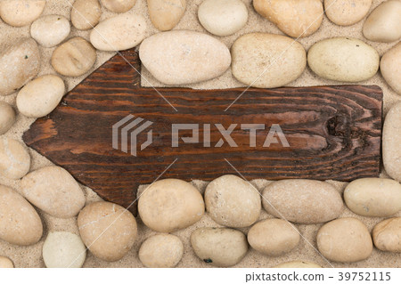 Classical wooden arrow and white stones on  sand. 39752115