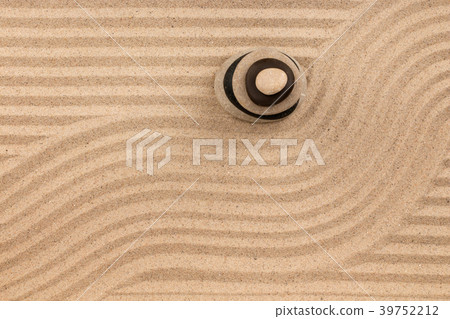 Pyramid made of stones standing on  striped sand. 39752212