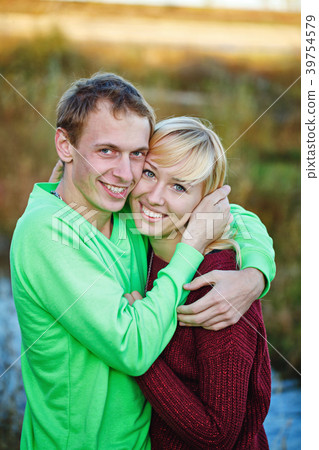 Young couple on banks of river Young couple on banks of river 39754579