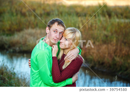 Young couple on banks of river Young couple on banks of river 39754580