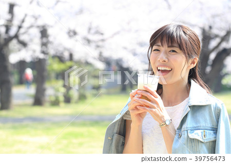 Woman drinking beer in the park 39756473