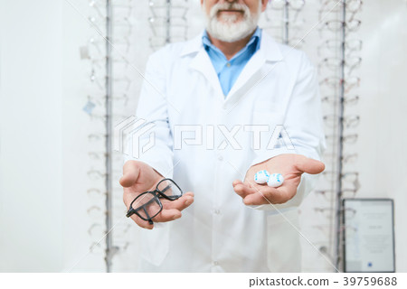 doctor advising to try the eyeglasses on. doctor advising to try the eyeglasses on. 39759688