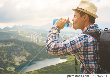 Traveler drinks water in the mountains Traveler drinks water in the mountains 39762261