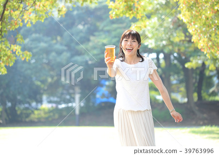 女人在公園裡喝啤酒 女人在公園裡喝啤酒 39763996