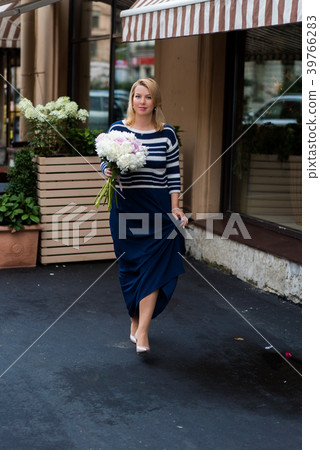 Young blonde woman in blue dress with peonies Young blonde woman in blue dress with peonies 39766283