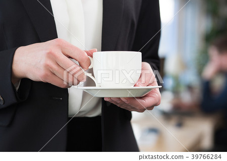 Beautiful businesswoman drinking coffee in office Beautiful businesswoman drinking coffee in office 39766284