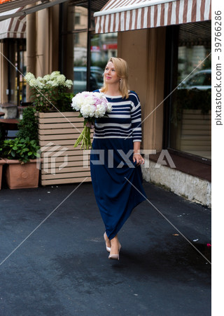 Young blonde woman in blue dress with peonies Young blonde woman in blue dress with peonies 39766286