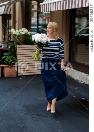 Young blonde woman in blue dress with peonies 39766287