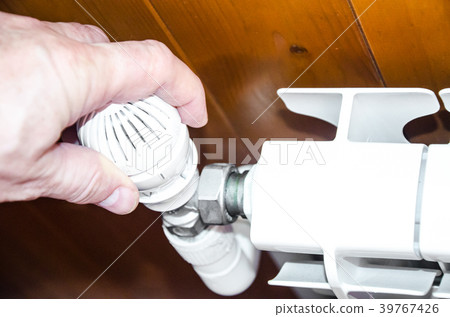 Hand regulates temperature in radiator Hand regulates temperature in radiator 39767426