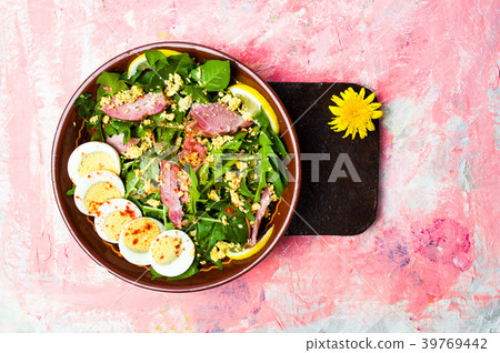 Dandelion salad with eggs meat and lemon in a bowl 39769442
