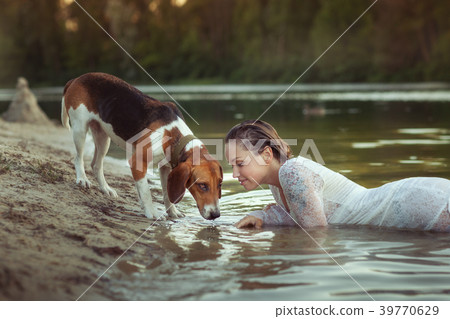 Beautiful woman lies in the water on the beach. 39770629