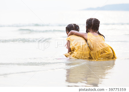 two cute asian little child girls hugging on beach two cute asian little child girls hugging on beach 39775359