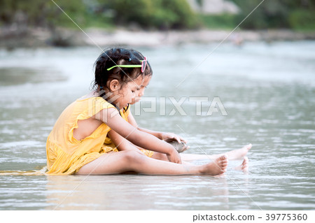 Two asian child girl sitting and playing with sand Two asian child girl sitting and playing with sand 39775360
