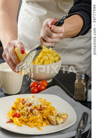 Chef prepares tagliatelle with garlic and cherry tomatoes 39777494