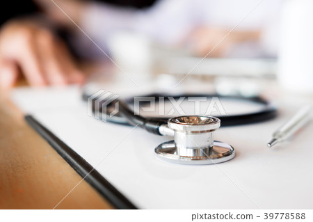 View of stethoscope and equipment on foreground table with docto 39778588
