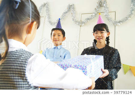 Child giving a party present Child giving a party present 39779124