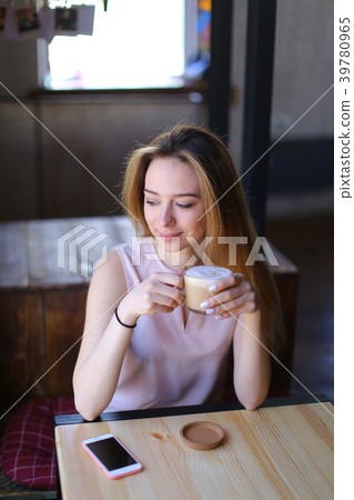 Young woman sitting near table with white 39780965